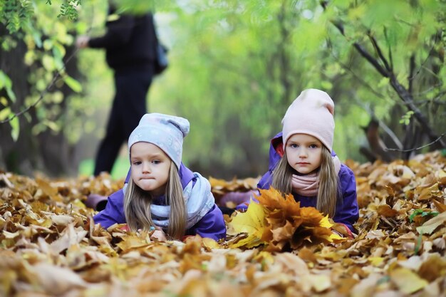 Caída de hojas en el parque Niños de paseo en el parque de otoño Familia Otoño Felicidad