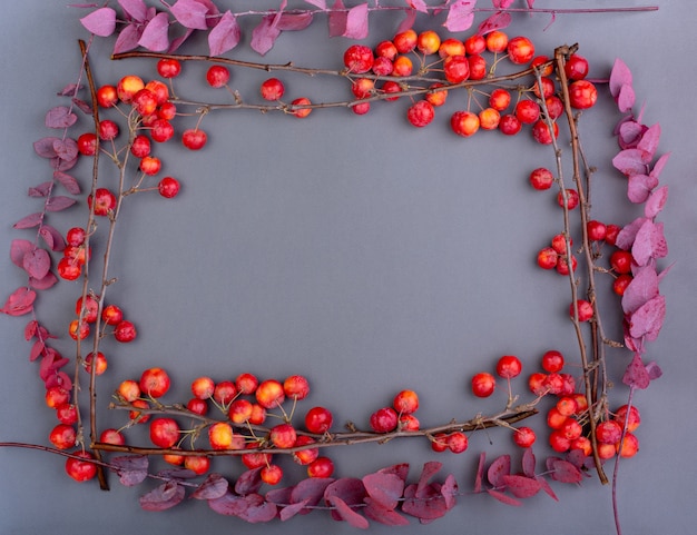 Caída plana con manzanas rojas y hojas de otoño marchitas en gris