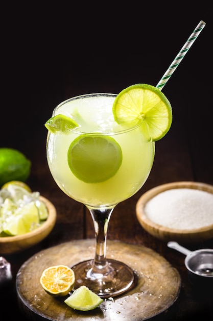 Caipirinha bebida alcohólica típica brasileña hecha con azúcar de limón cachaca y frutas bebida fría de verano en un ambiente rústico con copyspace