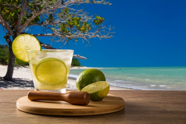 Caipirinha de fruta de limón de Brasil sobre hermosa playa