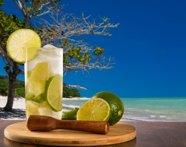 Caipirinha de fruta de limón de Brasil sobre hermosa playa