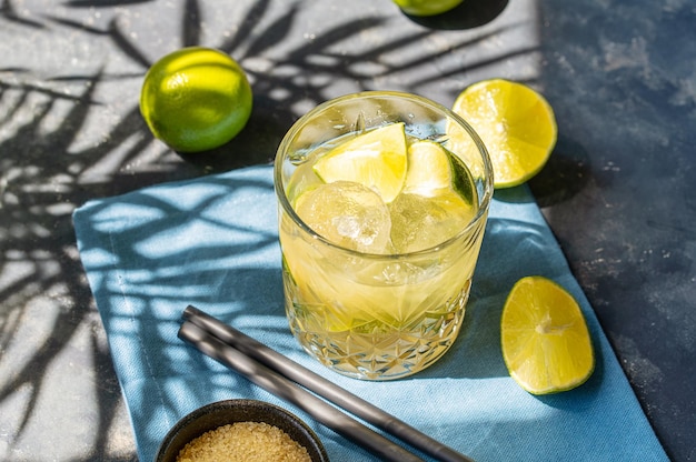 Caipirinha ist ein traditioneller brasilianischer Cocktail aus Rum-Limette und Rohrzucker. Starke Palmschatten