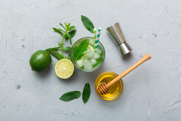 Caipirinha Mojito Cocktail Wodka oder Sodagetränk mit Limettenminze und Strohhalm auf Tischhintergrund Erfrischungsgetränk mit Minze und Limette in Glasdraufsicht flach gelegt