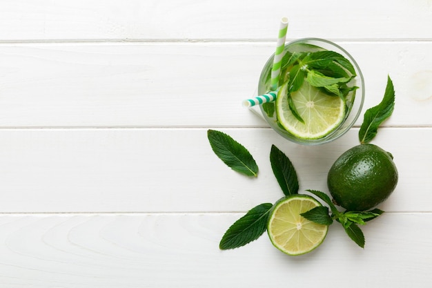 Caipirinha Mojito Cocktail Wodka oder Sodagetränk mit Limettenminze und Strohhalm auf Tischhintergrund Erfrischungsgetränk mit Minze und Limette in Glasdraufsicht flach gelegt