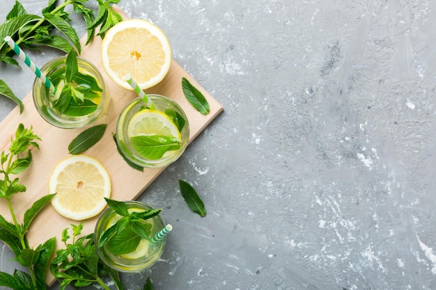 Caipirinha Mojito Cocktail Wodka oder Sodagetränk mit Limettenminze und Strohhalm auf Tischhintergrund Erfrischungsgetränk mit Minze und Limette in Glasdraufsicht flach gelegt