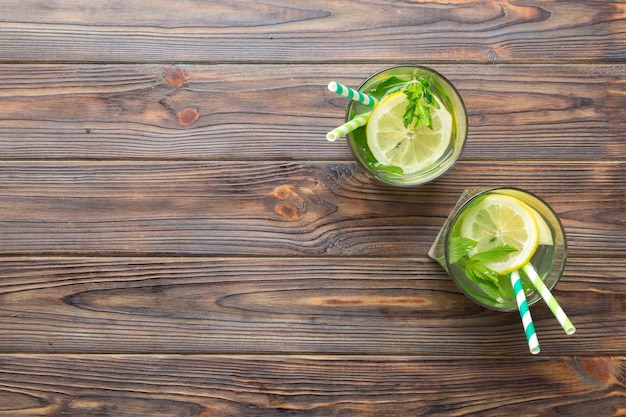 Caipirinha Mojito cóctel vodka o bebida gaseosa con menta lima y paja en el fondo de la mesa Bebida refrescante con menta y lima en la parte superior de vidrio vista plana