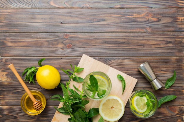 Caipirinha Mojito cóctel vodka o bebida gaseosa con menta lima y paja en el fondo de la mesa Bebida refrescante con menta y lima en la parte superior de vidrio vista plana