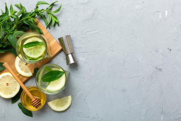 Caipirinha Mojito cóctel vodka o bebida gaseosa con menta lima y paja en el fondo de la mesa Bebida refrescante con menta y lima en la parte superior de vidrio vista plana