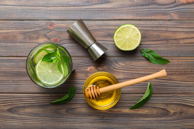 Foto caipirinha mojito cóctel vodka o bebida gaseosa con menta lima y paja en el fondo de la mesa bebida refrescante con menta y lima en la parte superior de vidrio vista plana