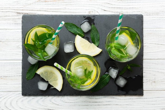 Caipirinha Mojito cóctel vodka o bebida gaseosa con menta lima y paja en el fondo de la mesa Bebida refrescante con menta y lima en la parte superior de vidrio vista plana