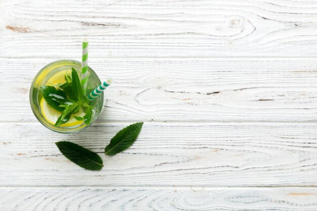 Caipirinha Mojito coquetel vodka ou refrigerante com hortelã e canudo no fundo da mesa Bebida refrescante com hortelã e limão em vidro vista superior plana lay