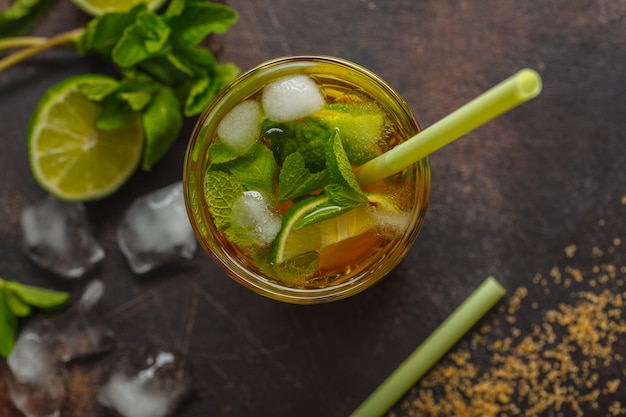 Caipirinha tradicional brasileira com limão, açúcar e hortelã. Fundo escuro, vista de cima, copie o espaço.