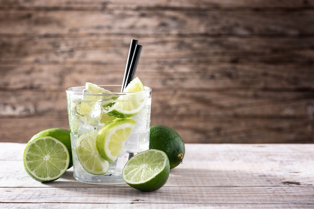 Caipiroska Cocktail mit Limette auf Holztisch