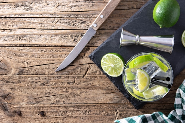 Caipiroska Cocktail mit Limette auf Holztisch