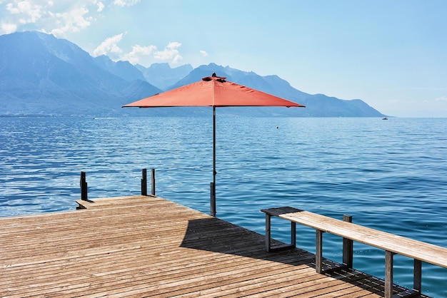 Cais com guarda-chuva no Lago Genebra de Montreux, Riviera Suíça