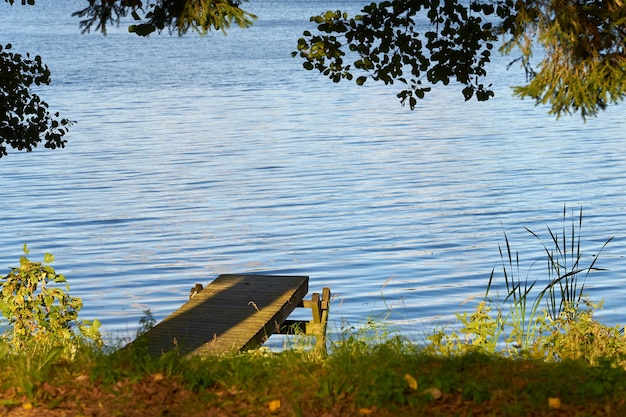 Cais de madeira na margem do lago outono.