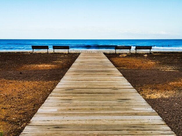 Cais de madeira, oceano azul e céu na superfície para o conceito de férias de férias de verão