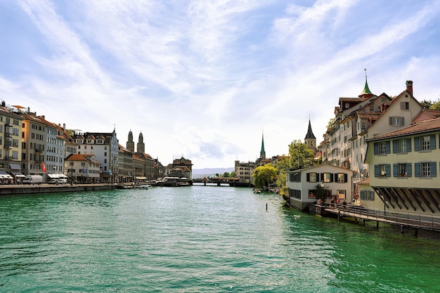 Cais do Rio Limmat com pináculos de três igrejas principais de Zurique - Grossmunster, Fraumunster e St Peter Church, Suíça