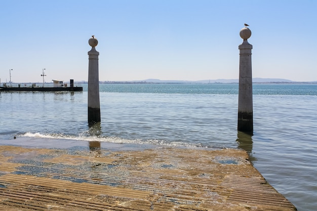 Cais na praça central de Lisboa junto ao rio Tejo.