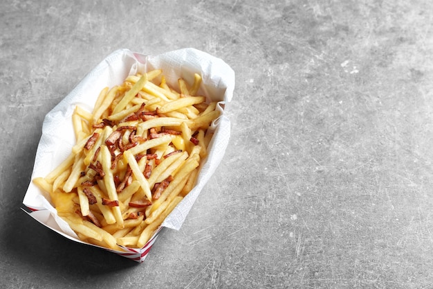 Caixa com batata frita e bacon na mesa