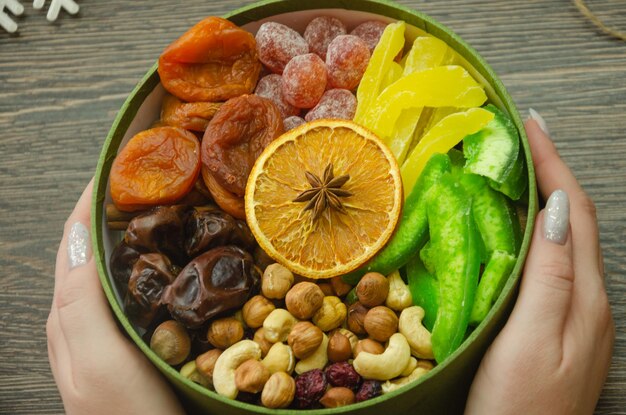 Foto caixa com nozes e frutas secas para segurar em suas mãos na mesa decorações de natal