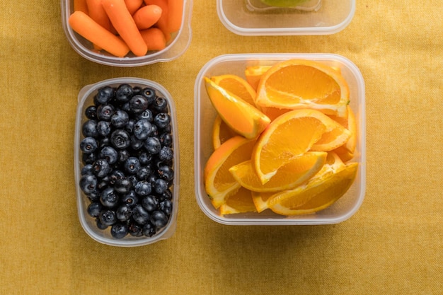 Caixa de almoço com lanches saudáveis recipiente de plástico com frutas e legumes em close-up