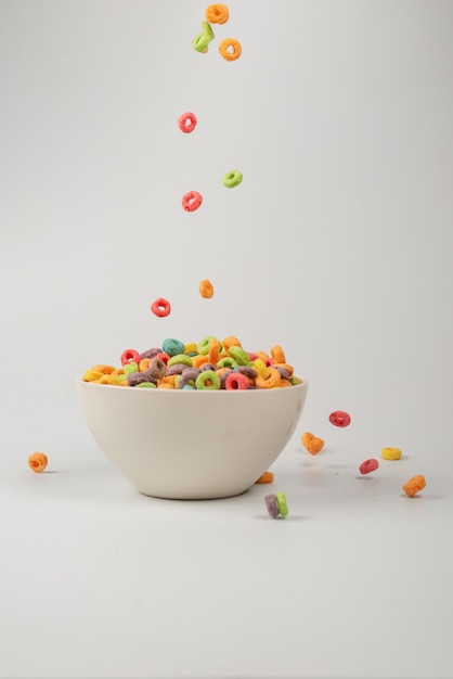 Caixa de cereal colorida para o café da manhã Flocos de milho caindo na tigela branca Movimento