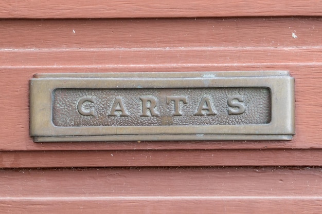Caixa de correio enferrujada velha com as letras da palavra em cartas espanholas