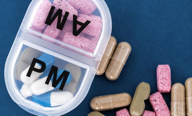 Caixa de dose de medicamento Pílulas de prescrição e vitaminas em uma caixa de comprimidos branca Configuração plana e espaço para texto