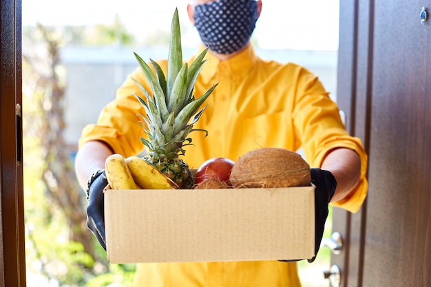 Caixa de entrega de correio homem com comida de frutas exóticas, entrega sem contato.