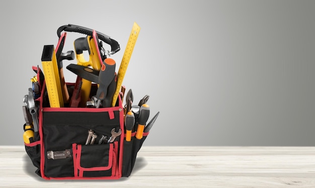 Caixa de ferramentas com várias ferramentas de trabalho na mesa de madeira