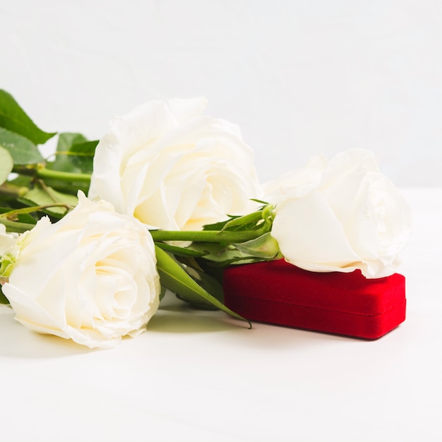 Caixa de joias vermelha com buquê de rosas brancas