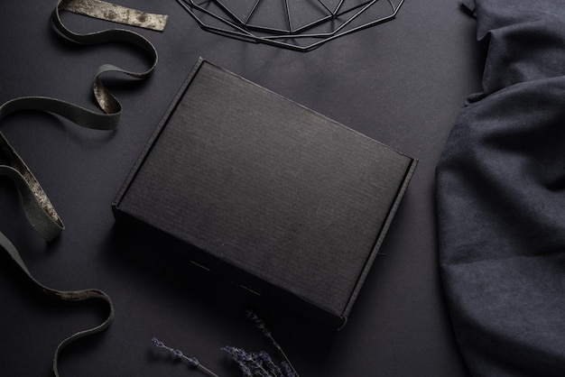 Caixa de pacote de papelão preto sobre fundo escuro