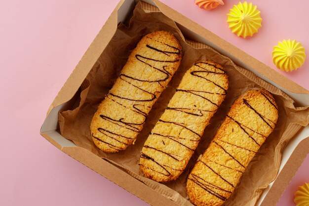 Caixa de papelão com biscoitos de aveia na mesa rosa