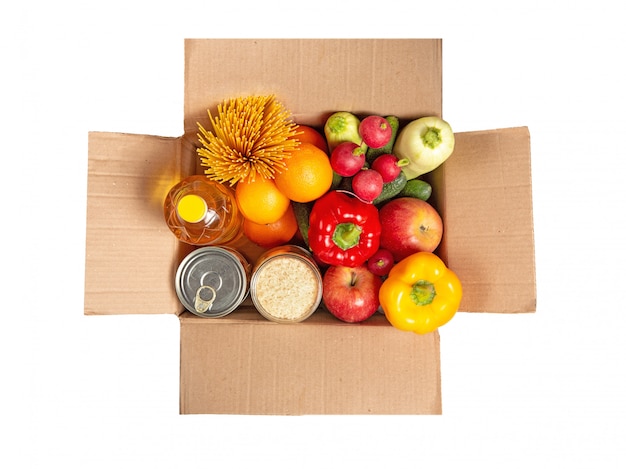 Caixa de papelão com um conjunto de alimentos. Frutas, legumes, comida enlatada, óleo vegetal, espaguete. Entrega de alimentos. Conjunto de supermercado.