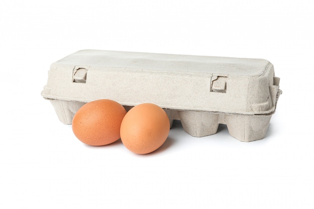 Foto caixa de papelão e ovos de galinha isolados no branco