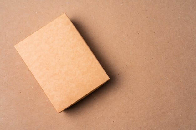 Caixa de papelão em fundo bege no estúdio