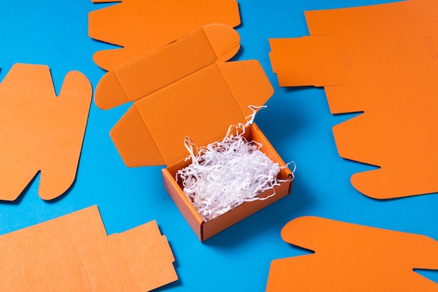 Caixa de papelão laranja com enchimento de papel picado branco
