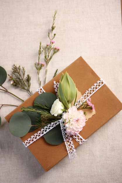 Caixa de presente artesanal com flores na mesa