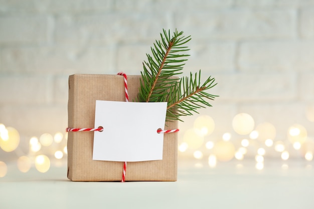 Caixa de presente artesanal de Natal decorada com galho verde e cartão-presente vazio em branco. Conceito de Natal e ano novo.