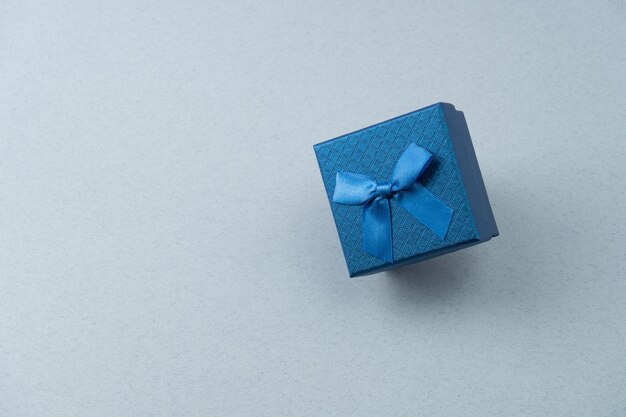 Caixa de presente azul com um laço na costela
