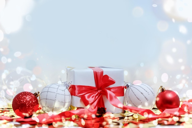 Caixa de presente branca com fita vermelha e bolas de Natal. Cartão de composição de natal