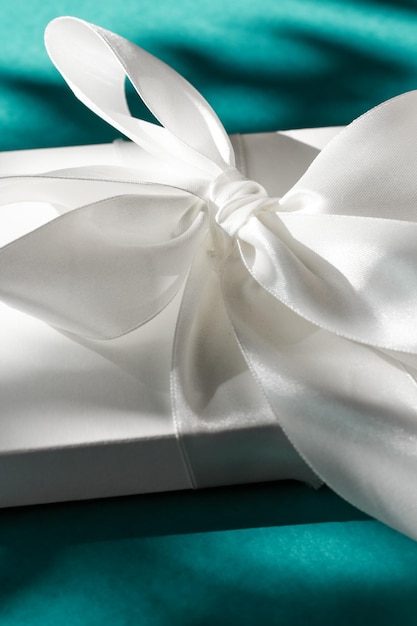 Caixa de presente branca de férias de luxo com fita de seda e arco em fundo verde esmeralda luxe casamento ou presente de aniversário