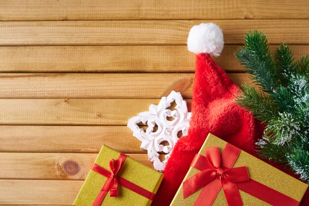 Caixa de presente, chapéu de Papai Noel, ramo de abeto em fundo de madeira. Conceito de Natal e ano novo Copiar espaço