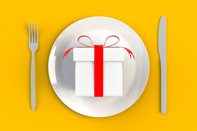 Caixa de presente com fita vermelha no prato, faca e garfo amarelo
