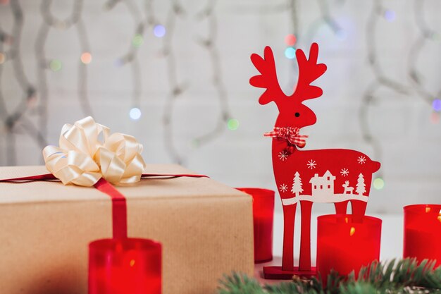 Caixa de presente com fita vermelha, veado-vermelho e velas