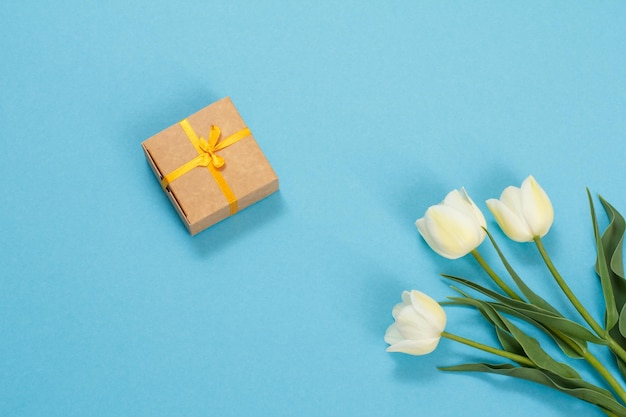 Caixa de presente com flores de tulipa em um fundo azul