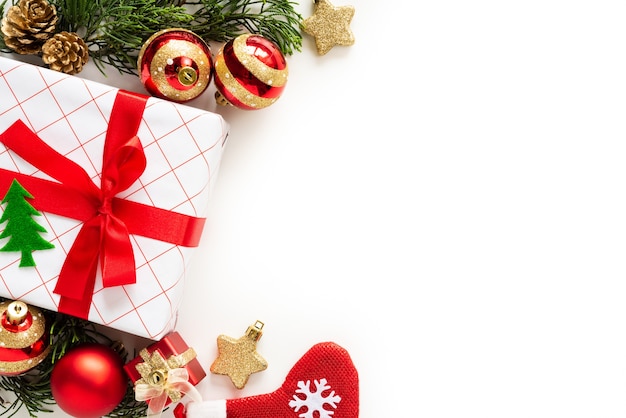 Caixa de presente de Natal com cones de bola e pinho vermelhos sobre fundo branco.