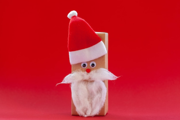 Caixa de presente de Natal criativa em forma de chapéu de Papai Noel e barba em fundo vermelho.