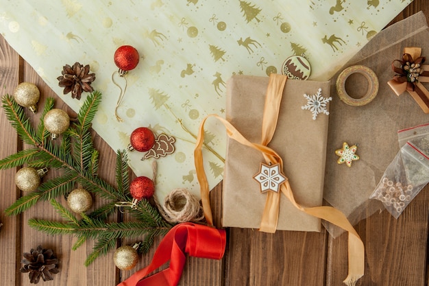 Caixa de presente de Natal, decoração e abeto galho de árvore na mesa de madeira. Vista superior com copyspace